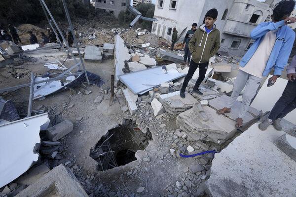 Palestinians look at the building of the Darwesh family, killed in the Israeli bombardment of the Gaza Strip, in Nusseirat refugee camp, central Gaza Strip, Monday. Picture: AP Photo/Adel Hana