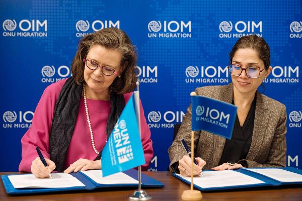 UN Women Deputy Executive Director Kirsi Madi (left) signs a new partnership with Catalina Devandas, IOM Representative of the Director General Office of Partnerships, Advocacy, and Communication.