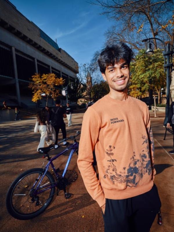 Man smiles at camera in front of bicycle