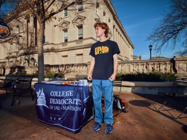 a man standing next to a table looks off to the side